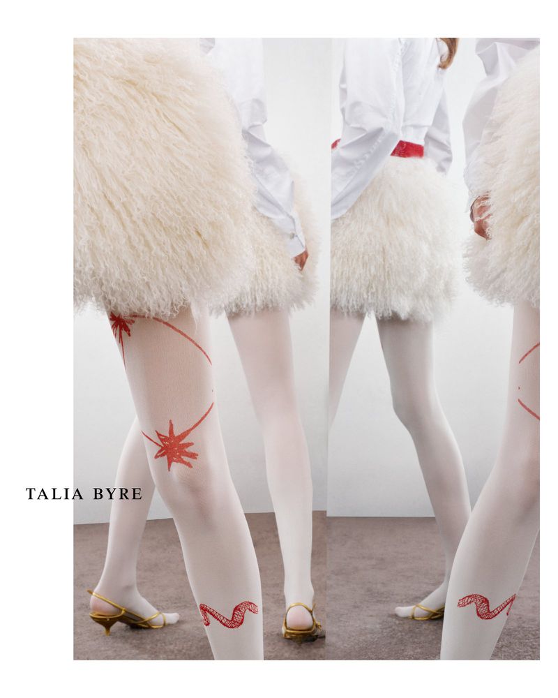 Fashion shot showcasing a woman's legs with white tights, gold heels, and a fluffy white skirt, featuring red star and snake designs.