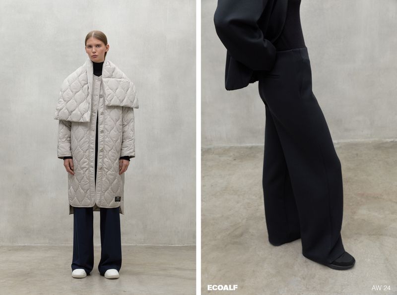 Fashion editorial shot of a woman wearing a beige quilted coat with a wide collar, wide-leg dark pants, and white sneakers, on set.