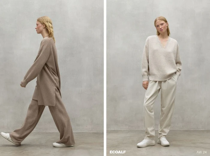 Model wearing neutral knitwear and trousers posing against a grey textured studio wall for Ecoalf Woman collection AW24