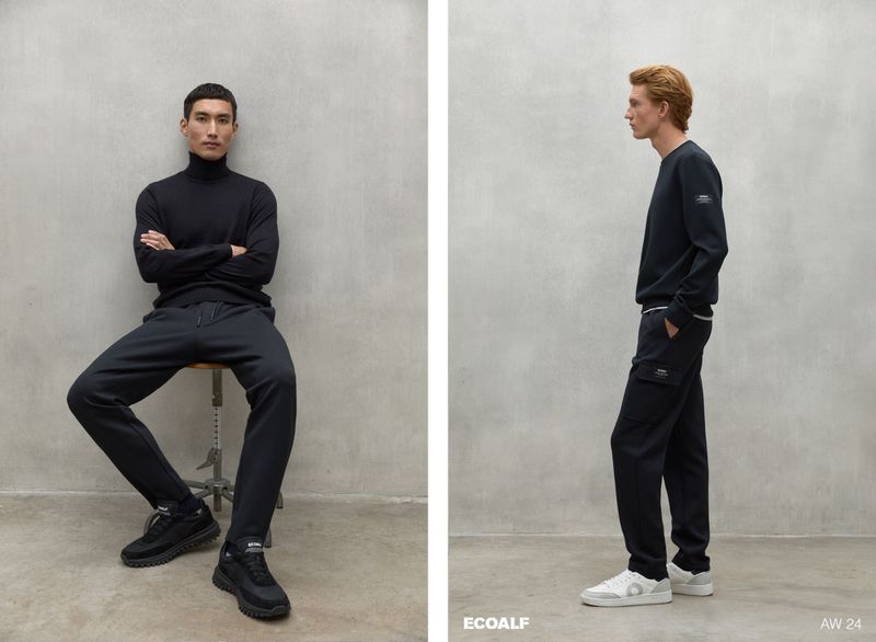 Two men showcase Ecoalf's AW 24 collection, one seated in black, the other in profile, against a neutral backdrop in a fashion-forward scene.