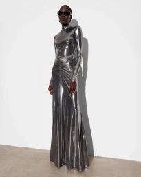 Model in shiny silver metallic long-sleeve gown wearing dark sunglasses against a white background.