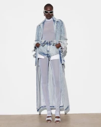 Model Nanny Malual wearing a long acid wash denim coat, matching shorts, sheer leggings, and white sunglasses for LaPointe.