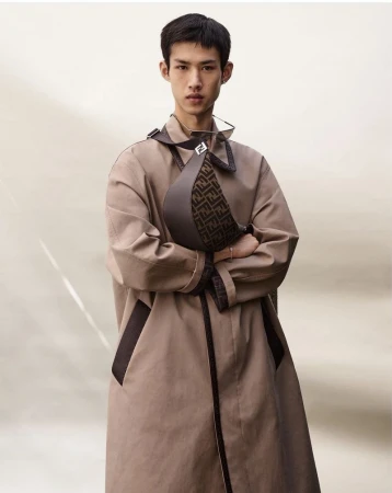Wu Guoqiang wearing a beige Fendi trench coat and a monogram crossbody bag with arms crossed in front of a neutral backdrop.