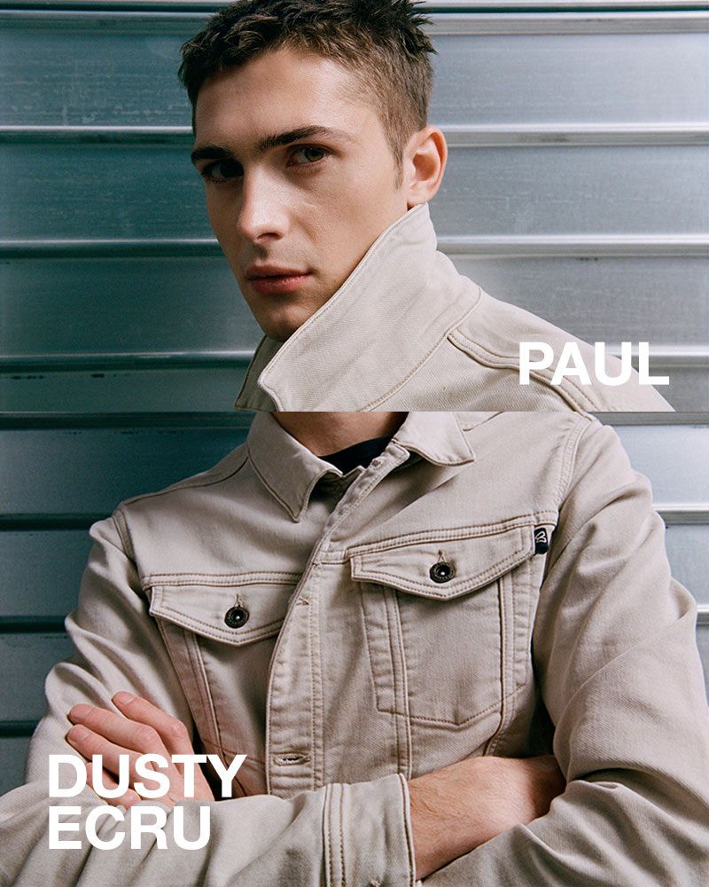 Close-up of a light-skinned adult male in a casual jacket with arms crossed against a metal background with 'Paul' and 'Dusty Ecru' text.