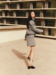 Model Ling Chen in a grey tweed jacket and matching mini skirt walking outdoors for ME+EM August Lookbook