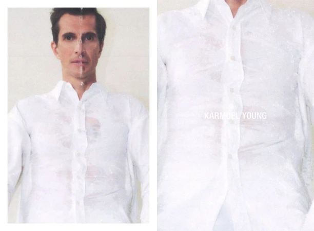 Portrait of an adult male wearing a wet white shirt. Studio lighting emphasizes the water droplets and fabric texture against a white backdrop.