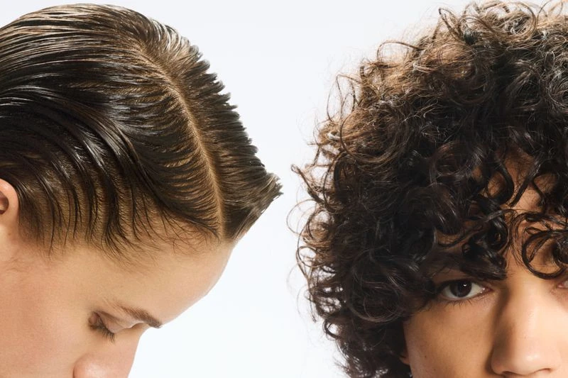 Two individuals with contrasting hair textures are positioned against a clean, bright white background, showcasing smooth and curly hair.