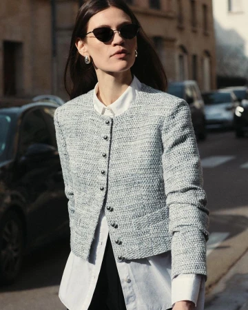Model wearing a textured tweed jacket and white shirt outdoors on a city street for Derek Lam Fall 2024 collection.