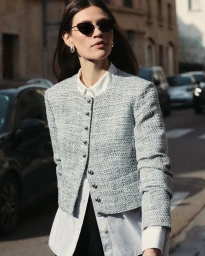 Model wearing a textured tweed jacket and white shirt outdoors on a city street for Derek Lam Fall 2024 collection.