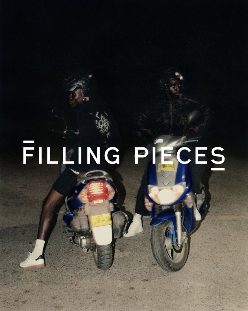 Two adults wearing helmets sit astride scooters parked outdoors at night, with a white title overlayed in the foreground.