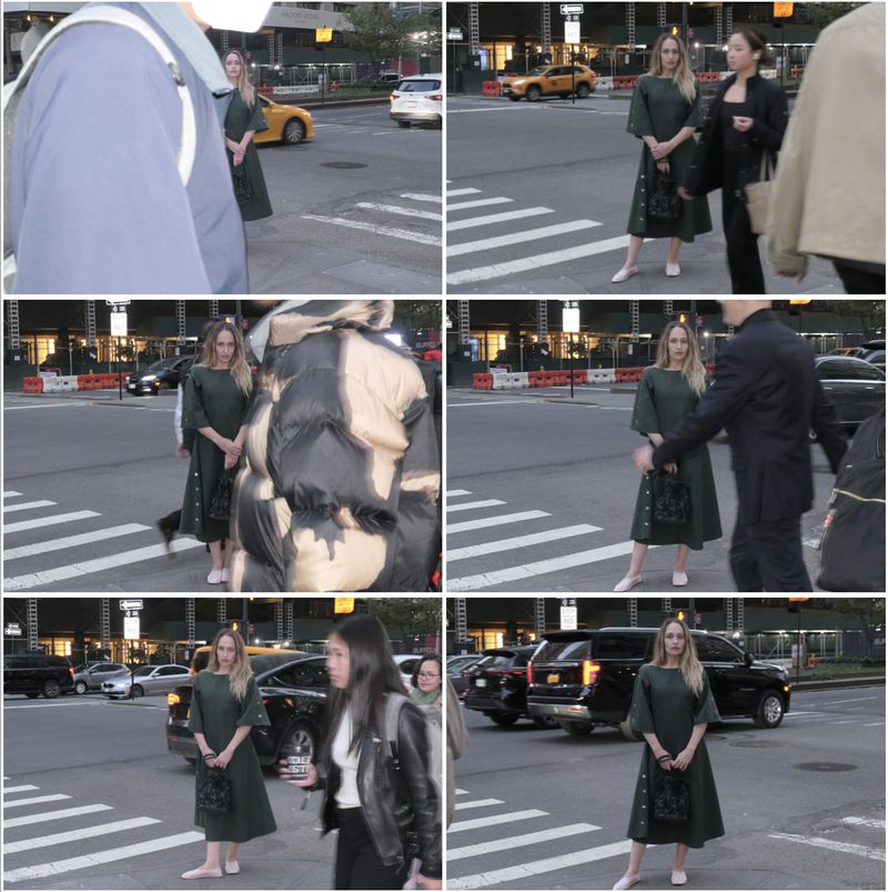 Outdoor shot of a woman in a green dress on a city street crosswalk, captured at eye-level with street traffic and pedestrians.