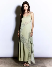 Model wearing a light green slip dress with patterned diagonal panels against a plain studio background