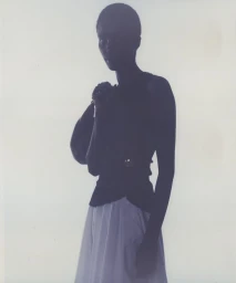 Model in silhouette wearing a dark sleeveless top and light skirt against a plain white background for Loewe SS24