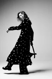 Giulia Maenza in a black and white polka dot outfit stepping forward against a studio backdrop for Falconeri Summer 2024.
