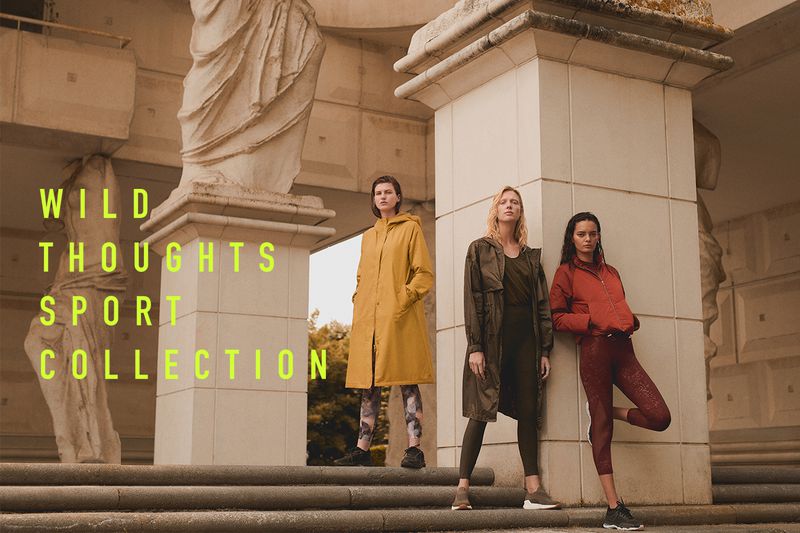 Three adult women model sportswear in front of a classical architectural structure with yellow-green text overlaying the scene.