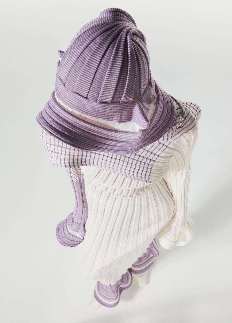 Overhead shot of a fashion garment featuring a light purple, striped hat and dress on a plain white background in a studio setting.