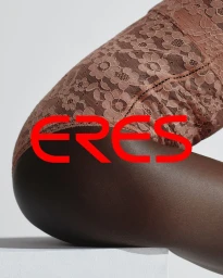 Close-up portrait of a model wearing brown lace lingerie against a clean white studio background with red brand lettering.