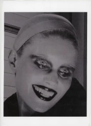 Close-up black-and-white portrait of a woman wearing a headband and dark lipstick, photographed by Casper Sejersen.