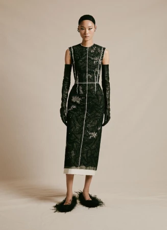 Elegant Asian model showcases black sequined dress with long gloves and feathered shoes in a studio fashion photoshoot.