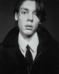 Black and white portrait of model Herman Ingerstedt wearing a dark zip-up jacket, white collared shirt, and black necktie.