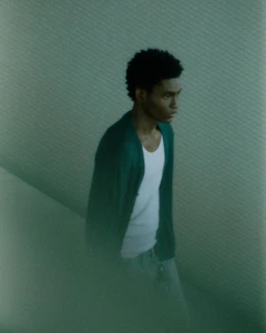 Evans Ikechukwu wearing a dark green cardigan over a white tank top for Zara Man Summer 2024.