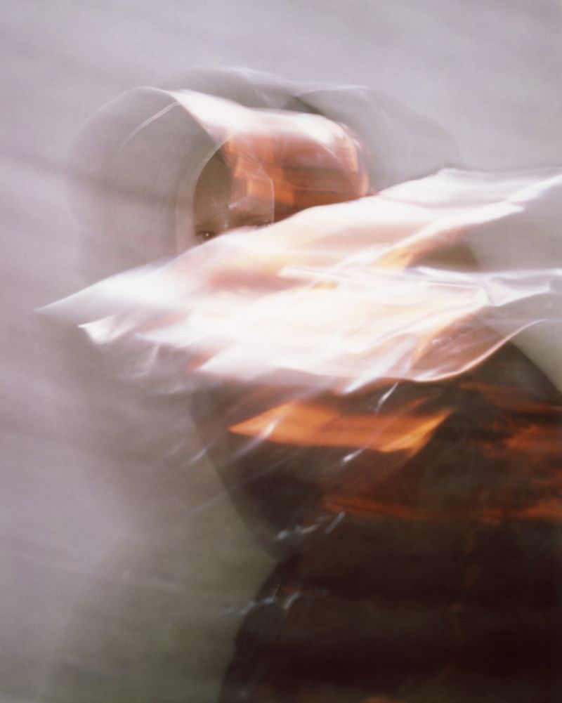 Abstract blurry portrait of a woman with red hair and fair skin. The photograph is artistically blurred, using long exposure and motion blur.