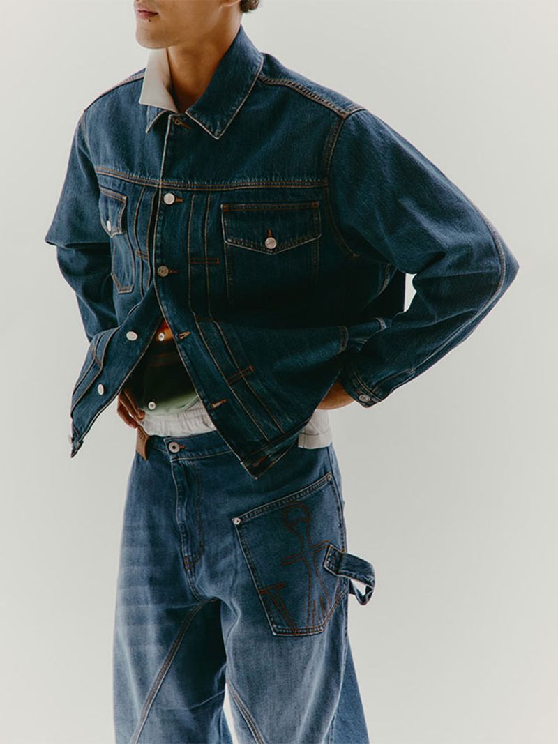 Denim fashion shoot features a male model wearing a blue denim jacket and wide-leg jeans against a neutral backdrop.