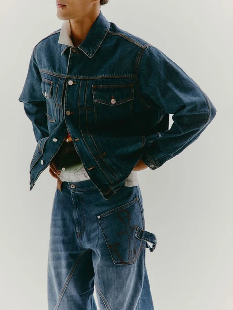 Denim fashion shoot features a male model wearing a blue denim jacket and wide-leg jeans against a neutral backdrop.
