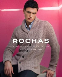 Male model wearing a beige cable-knit cardigan against a bright pink background for Rochas FW 24.