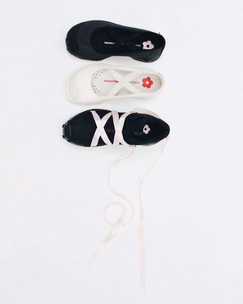 Three pairs of NOWWA x LARGERT ballet flats, in black and white, are arranged vertically against a seamless white backdrop, top-down.
