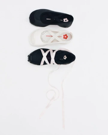 Three Sandy Liang x Salomon ballet sneakers in black and white with satin ribbon straps arranged on a seamless white surface.