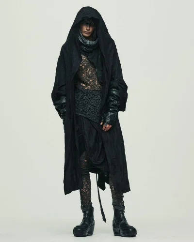 Model wearing a black hooded coat, distressed open-knit top, layered draping, and chunky boots against a neutral studio backdrop.