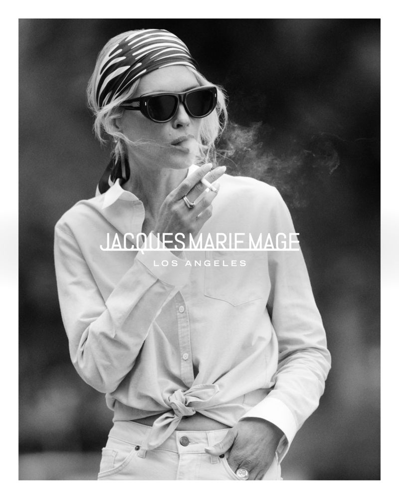 Black and white portrait of a blonde adult female smoking a cigarette, wearing sunglasses and headscarf, with brand text overlay.