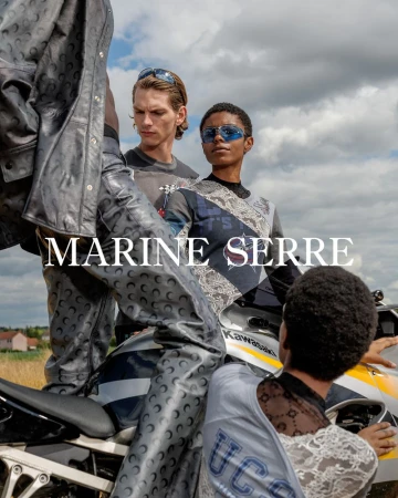Models wearing Marine Serre apparel on a motorcycle against a cloudy sky and field backdrop, showcasing fashion and outdoor style.