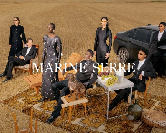 Editorial fashion shot outdoors with diverse models in formalwear, set against a wheat field backdrop, featuring a car and picnic setup.