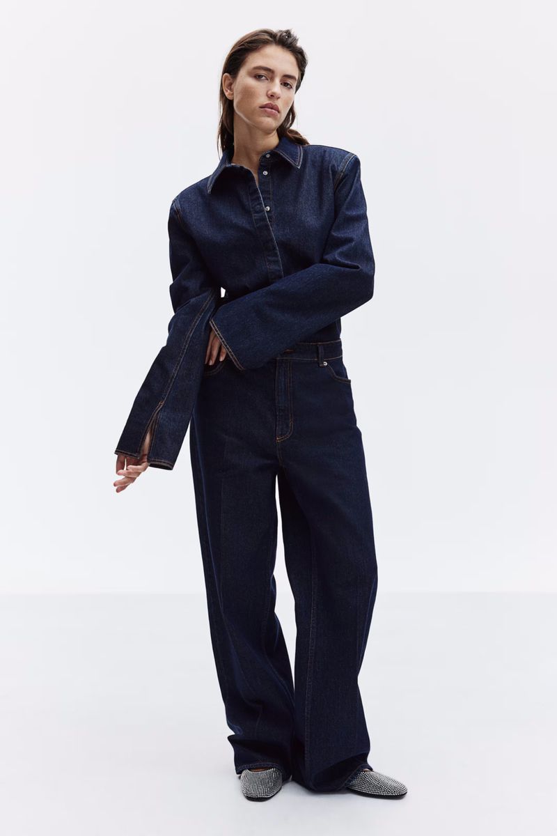 Model wearing a dark denim button-down shirt and matching trousers against a solid white background.