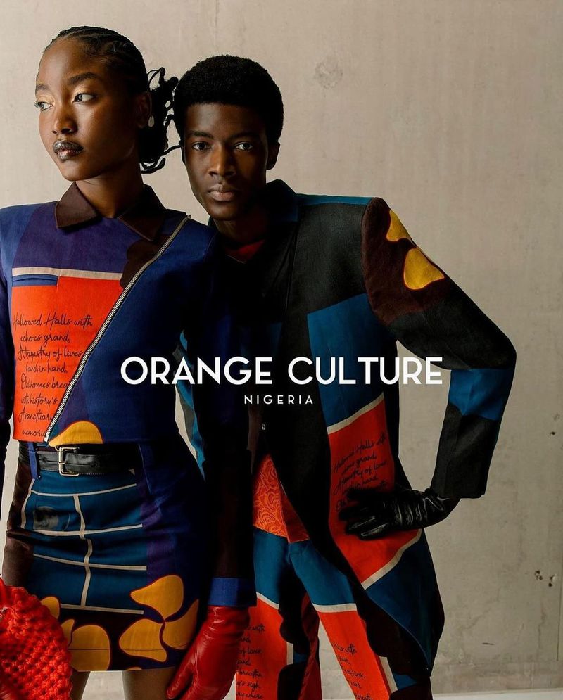 Two fashion models in patterned matching blazers and skirts; modern streetwear with orange, blue, and black color blocks in studio lighting.