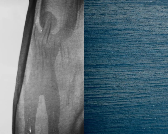 Abstract monochrome image featuring rippled ocean water and a grey human silhouette-like shape with a draped fabric texture.