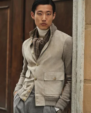 Model Juhyung Kang wearing a beige suede and knit jacket, white turtleneck, brown plaid scarf, and grey trousers.