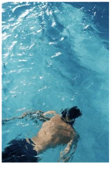 Man swimming underwater in a blue pool seen from above for Moss Resort SS24