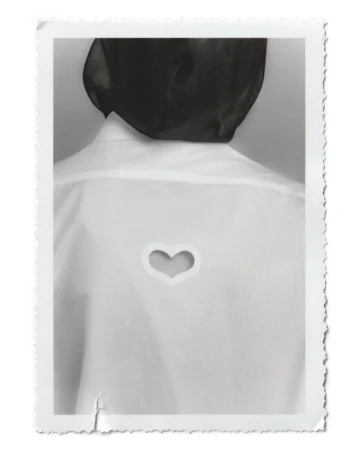 Back view of a person wearing a white shirt with a heart-shaped cutout against a neutral background within a white decorative border.
