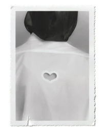 Rear view of a model in a white collared shirt featuring a heart-shaped cutout on the back, wearing a sheer black head covering.