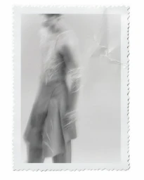 Motion-blurred photograph of a model against a light background inside a framed print with decorative edges.