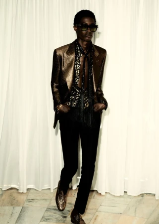 Model Daniel Awaridhe wearing a metallic bronze blazer, tinted sunglasses, and black trousers for the Tom Ford S/S 25 lookbook.