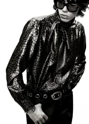 Model wearing dark sunglasses and a patterned silk blouse for Tom Ford S/S 25 men's lookbook against a white background