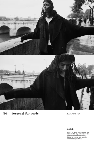 Monochrome image of a young adult female in a jacket, standing on a bridge with a Parisian cityscape, captured with a shallow depth of field.