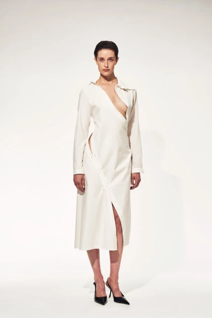 A single female model poses in a white midi dress with a plunging neckline and slit, complemented by black high heels in a studio shot.