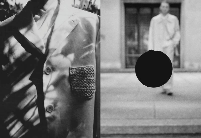 Monochrome image with a tailored jacket featuring a knitted pocket and a blurred figure in a coat walking in the background.