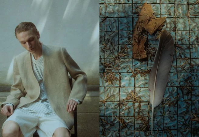 A fair-skinned male model in a beige jacket is seated indoors with a tile background featuring a leaf and a feather.