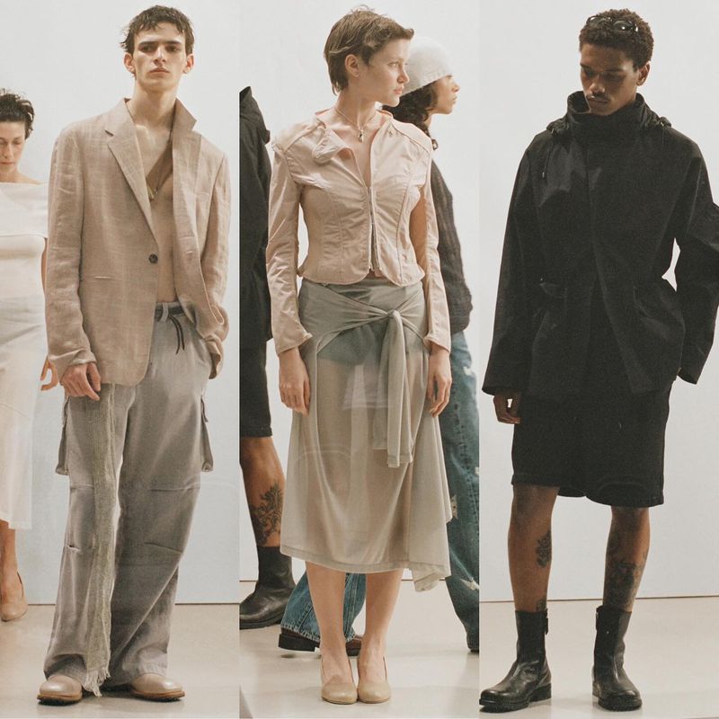 Fashion editorial shot: Several fashion models in neutral-toned garments pose against a white background in an eye-level, medium shot.